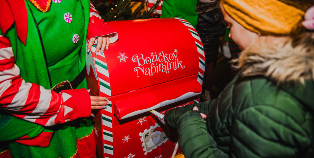 Deklica oddaja pismo v Božičkov nabiralnik - december v Bražicah